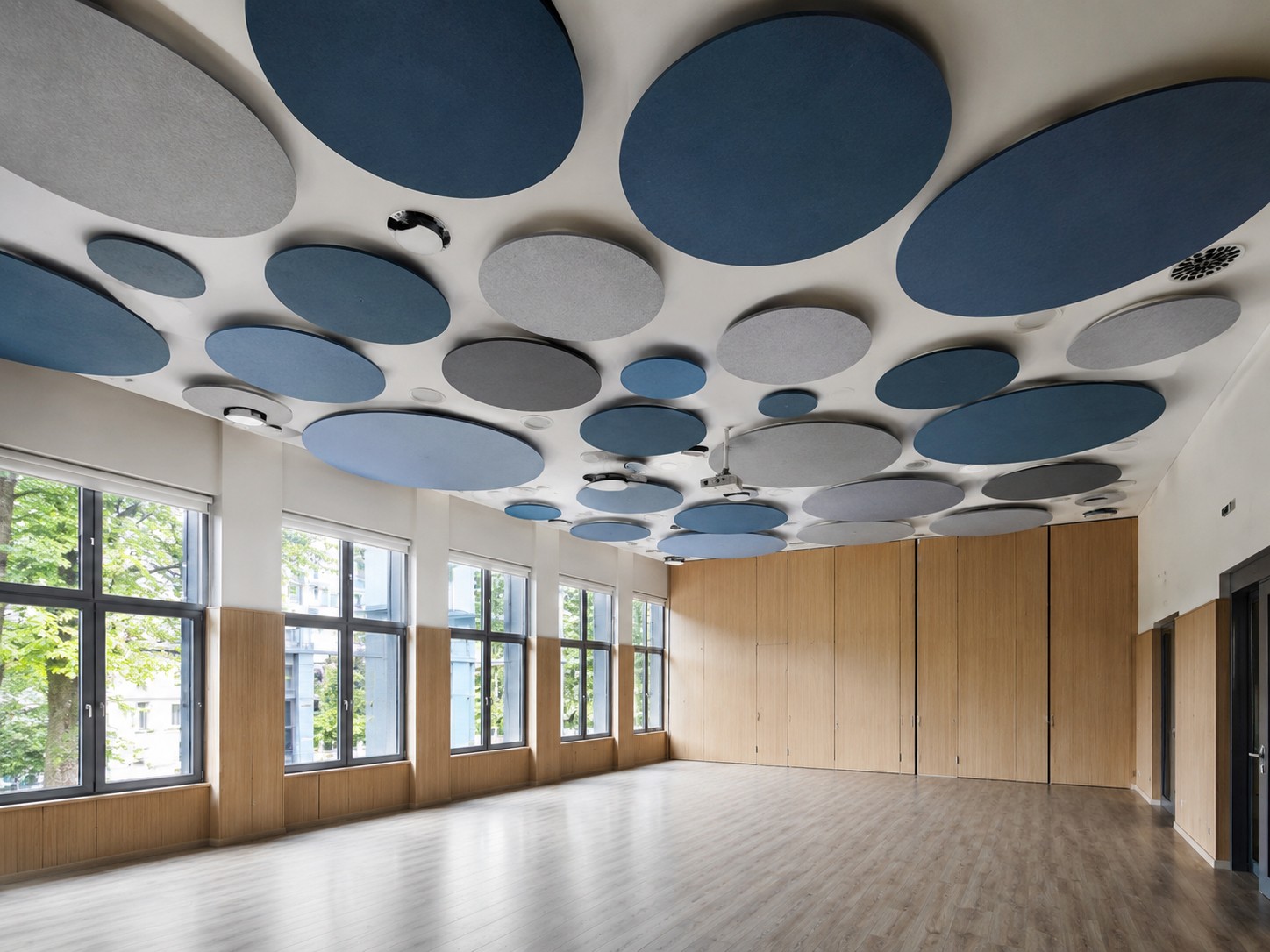Sala con tratamiento ac&uacute;stico de baffles circulares instalado por SILENOR